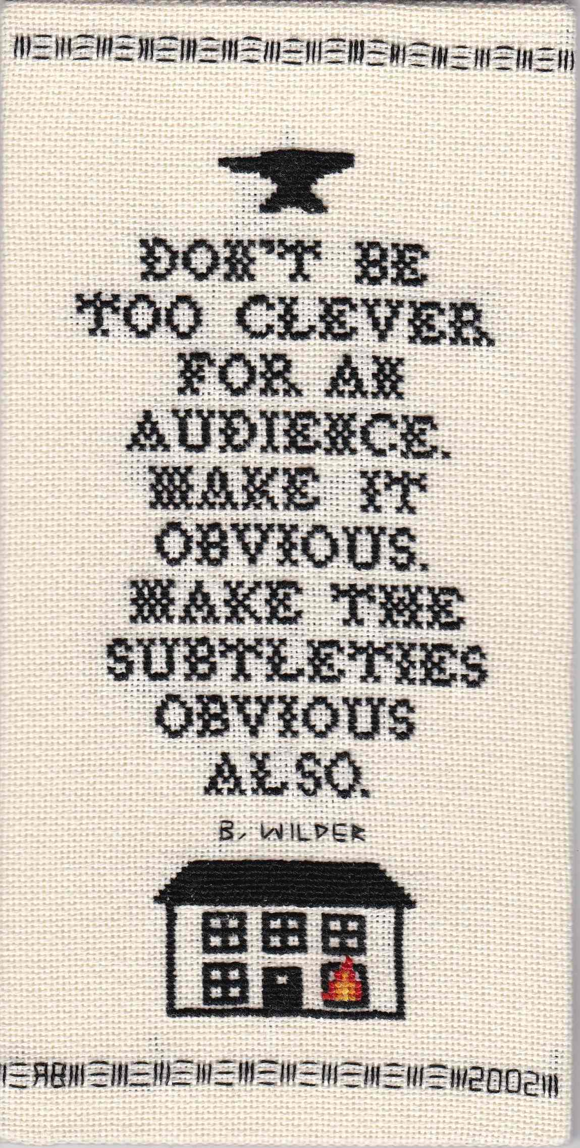 Cross-stitch sampler in black thread on ivory cloth